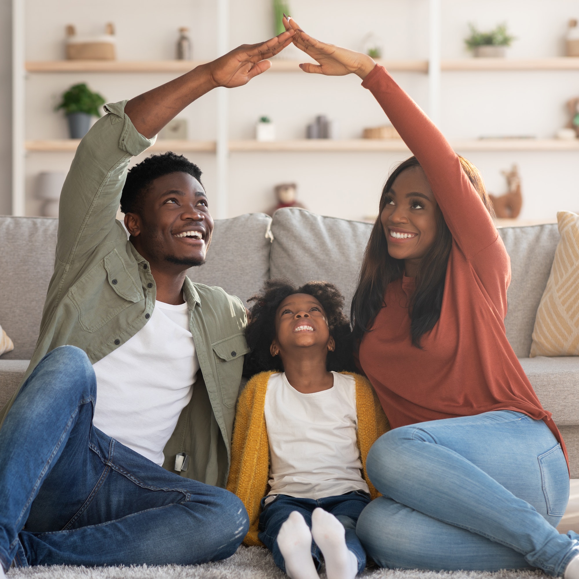 Family Care. Black Mom And Dad Making Roof Of Hands Above Daughter